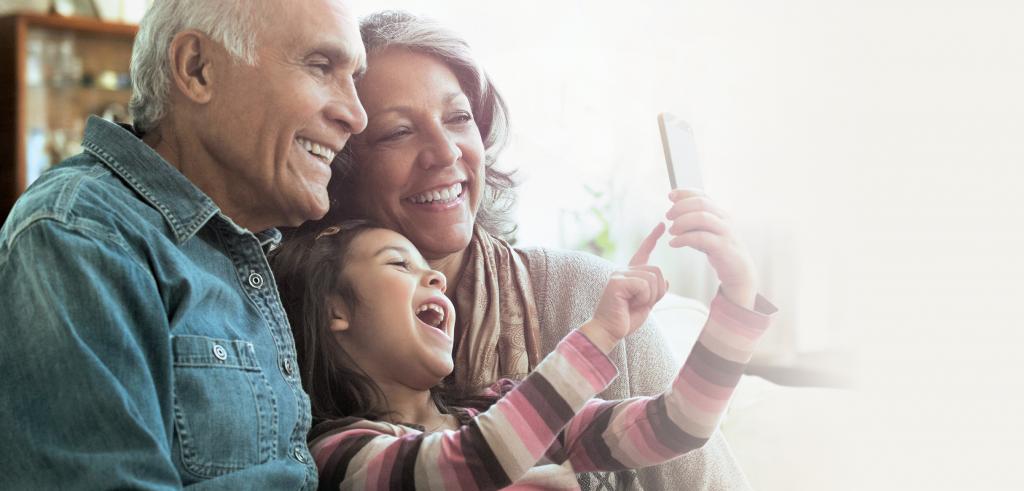 Grandparents with granddaughter on smartphone Grandparents with granddaughter on smartphone