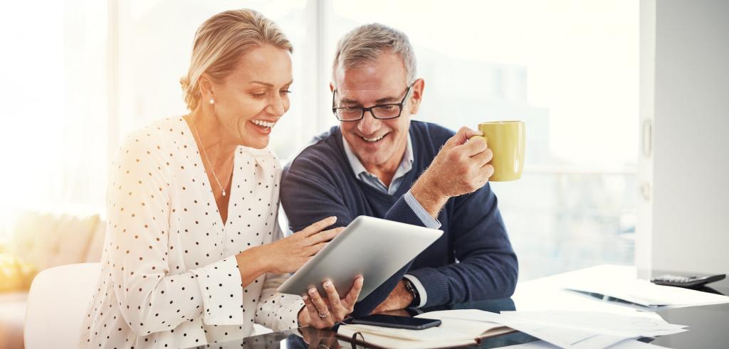 Un couple qui fon des verifications de leurs documents sur un appareil electronique Un couple qui fon des verifications de leurs documents sur une tablette