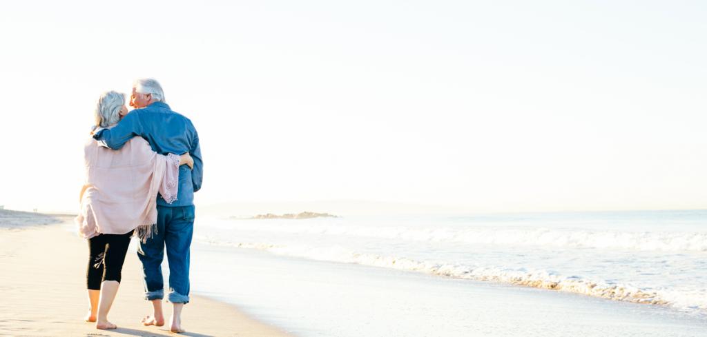 Retired couple walking on beach Retired couple walking on beach
