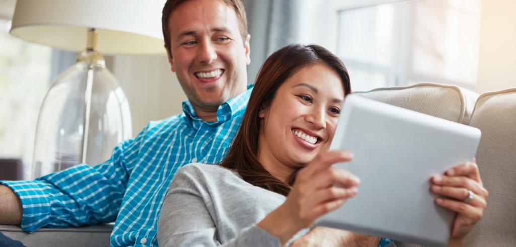 Young couple using tablet Young couple on couch using tablet