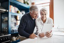  Middled aged couple in the kitchen reading tablet