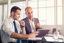 Two business people working on digital tablet