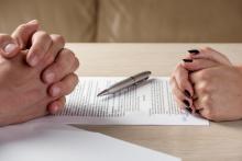 Une femme et un homme signent des documents