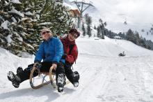 man and woman snow sledding
